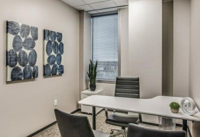 Private internal office suite with a white desk and large window.