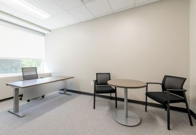 Private office suite with a desk and a small circular guest table.