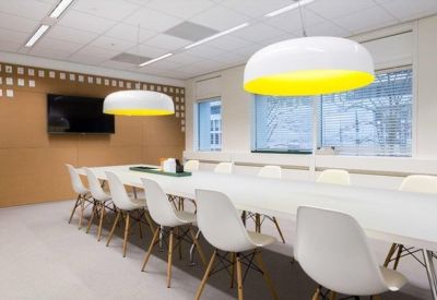 Minimalist meeting room with a long white table and modern dome pendant lights.