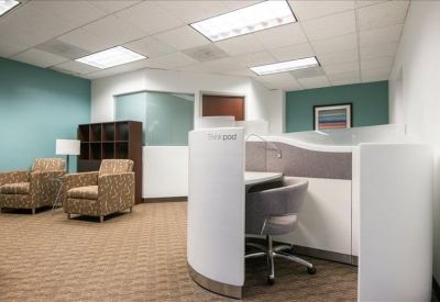 Cozy lounge area with patterned armchairs and a small white desk pod.