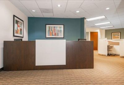 Modern reception area with a dark wood front desk and blue accent wall.