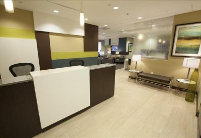 Professional reception desk with a white front and warm accent lighting.