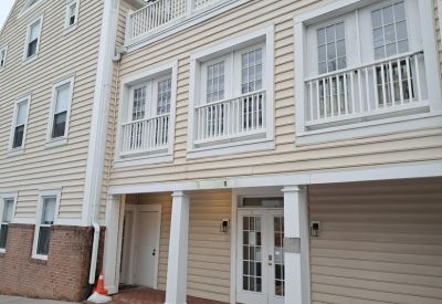 Main entrance with double glass doors and white columns.