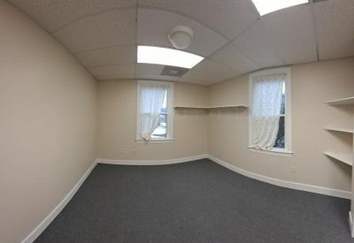 Private office featuring grey carpet and built-in shelving.