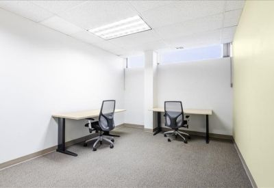 Reception lobby with a curved white desk and comfortable grey armchairs.