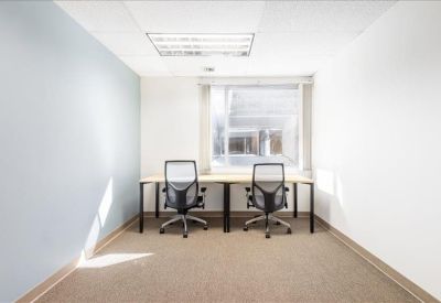 Private office suite for two with a large window and blue accent wall.