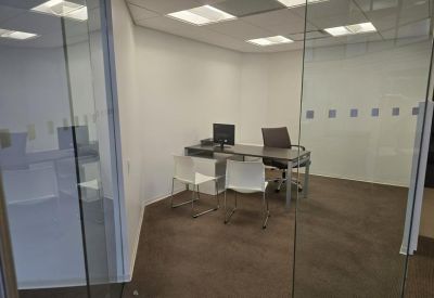 Small meeting room with glass walls and computer on desk