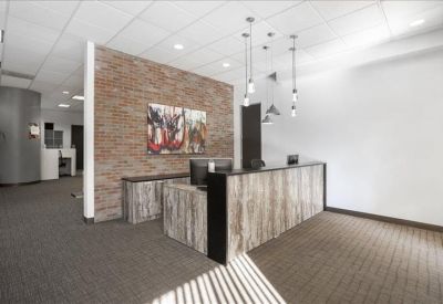 Reception area featuring a stone-textured desk and an exposed brick feature wall.