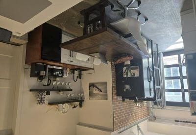 Communal kitchen area with coffee station and brick accent wall.