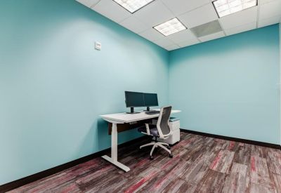 Private office suite with a teal feature wall and modern ergonomic chair.