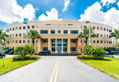 Exterior view of the curved facade and landscaped entrance at 8200 NW 41st Street.
