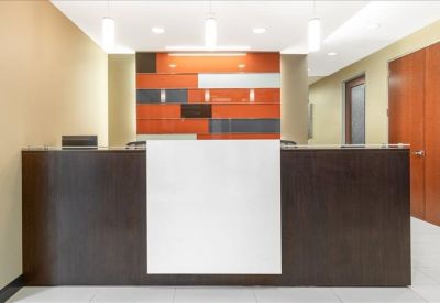 Sleek dark wood reception desk with a colorful geometric backdrop.