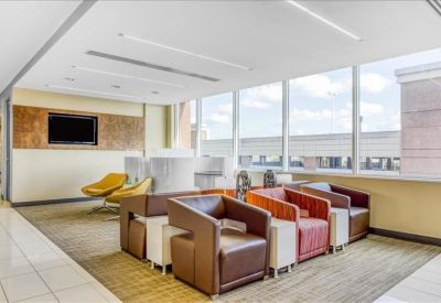 Modern lounge area with leather armchairs and a wall-mounted television.
