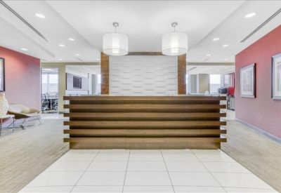 Reception area featuring a wood-slatted front desk and modern pendant lighting.