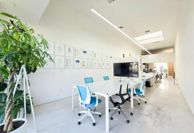 Bright meeting room with white table, blue chairs, and wall-mounted art prints.