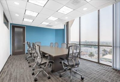 Large conference room featuring a blue accent wall and floor-to-ceiling city views.