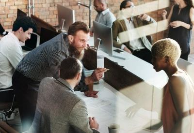 Coworking space with a group of professionals collaborating around a large desk.