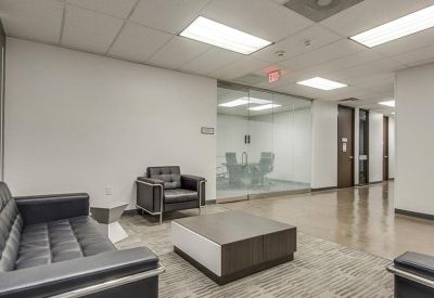 Contemporary office lounge with black leather seating and a modern coffee table.
