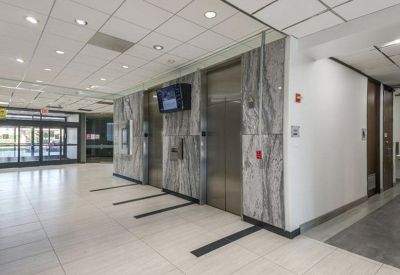 Modern elevator lobby with marble wall cladding and polished tile flooring.