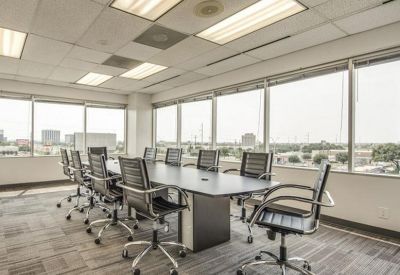 Spacious boardroom featuring a long conference table and large windows with city views.