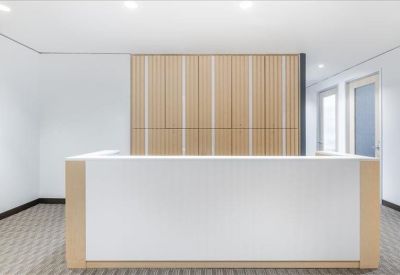 Clean, modern reception desk with a white front and vertical light wood paneling behind.