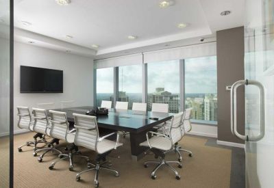 Corporate boardroom with white chairs, dark table, and expansive city skyline views.
