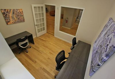 Internal office space featuring two workstations and abstract wall art.