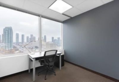 Private windowed office with city views and a grey accent wall.