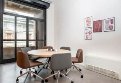 Small meeting room with a round table and framed wall art.