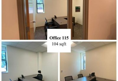 Office with desk and chairs near two windows.
