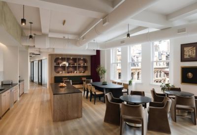Spacious communal dining area and kitchen with wooden floors and city views.