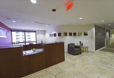 Professional reception area with wood-fronted desk and marble flooring.