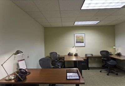 Multi-desk private office with wooden furniture and ergonomic chairs.