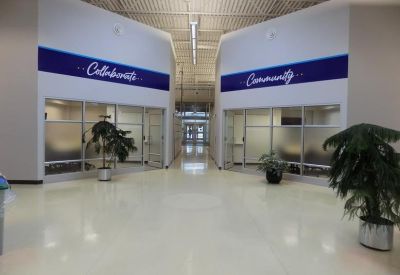 Spacious corridor area with glass-walled office suites labeled Collaborate and Community.