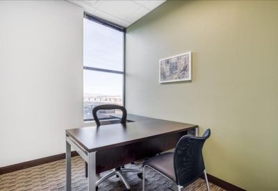 Private office with a dark wood desk and large window.
