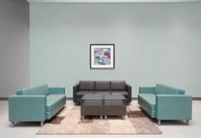 Modern lounge area with teal and chocolate brown sofas on a patterned rug.