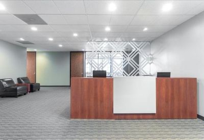 Professional reception area with a wood-fronted desk and decorative glass partition.