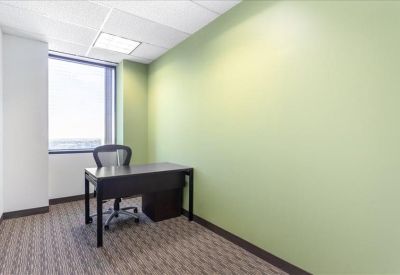 Private office suite with a green accent wall and large window.