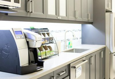 Modern grey kitchen with integrated appliances and a coffee station.