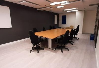 Modern workspace with a light wood table and acoustic wall panels.
