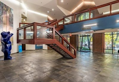 Spacious building lobby featuring a striking wood and glass staircase and large blue sculpture.