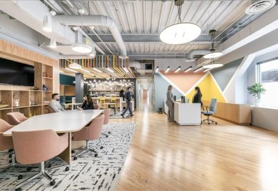 Spacious communal lounge with colorful geometric wall art and diverse seating areas.