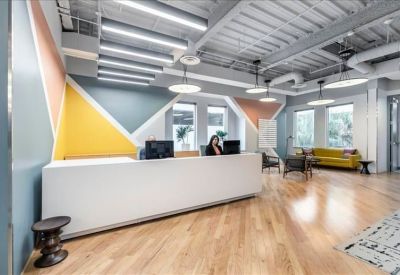 Modern reception area with a minimalist white desk and vibrant geometric wall patterns.