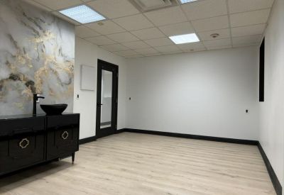 Office interior with a black vanity cabinet and marble feature wall.