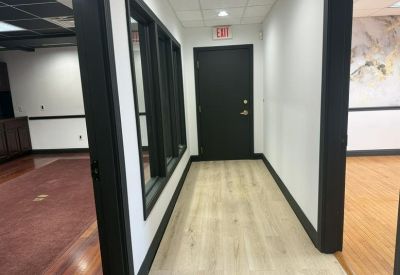 Hallway view looking into an office space with modern black doors.