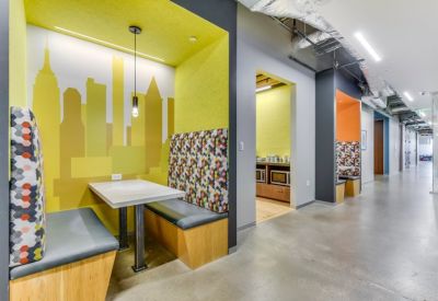 Semi-private booths with colorful patterned upholstery and yellow skyline wall art.