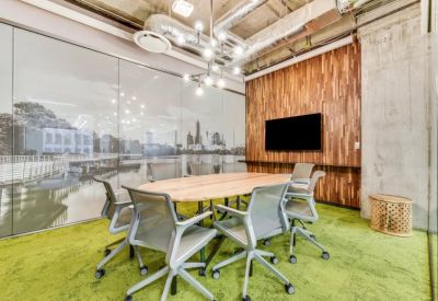 Glass-walled conference room with a city skyline mural and green carpeting.