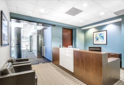 Bright reception area featuring a wood-fronted desk and comfortable lounge seating.