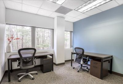 Private office with two desks, ergonomic chairs, and a large window.