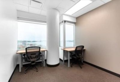 Bright corner office with two desks and large windows overlooking the water.